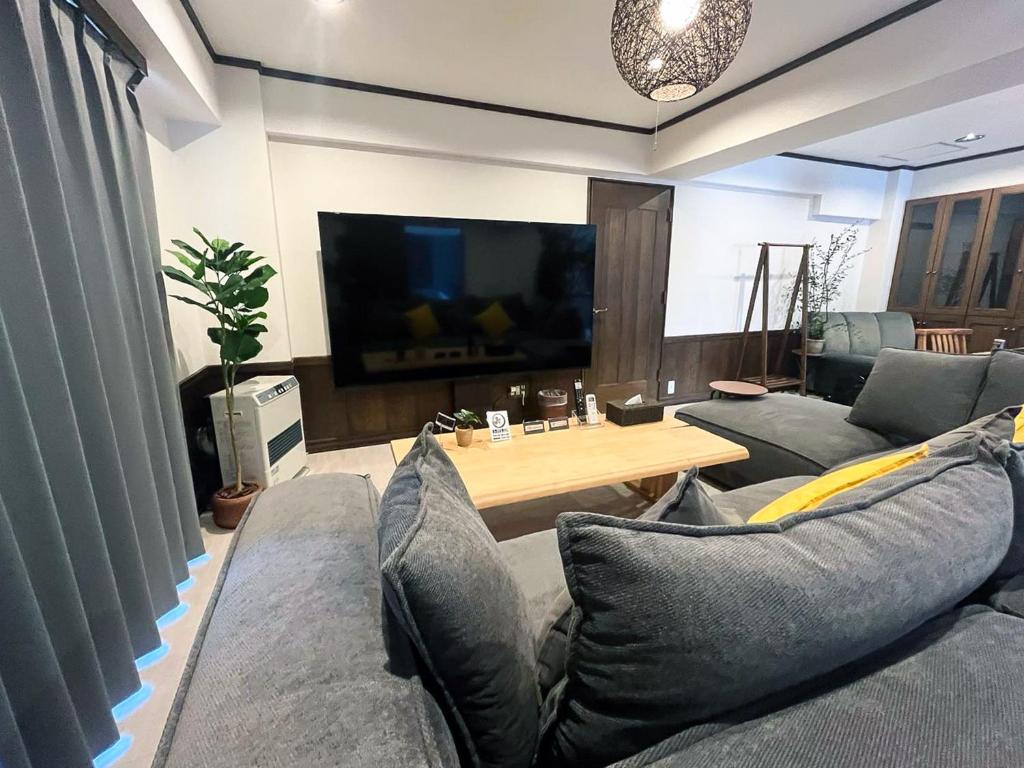 札幌市にあるLIT’S INN Sapporoのソファとテーブルのあるリビングルーム