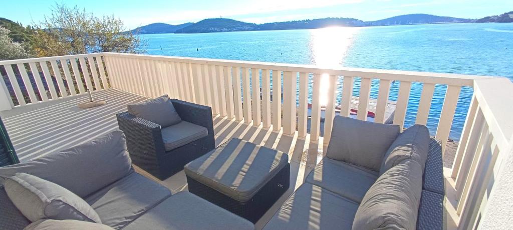 una terraza con sofá y sillas sobre el agua en Holliday house in Zatoglav, en Podglavica