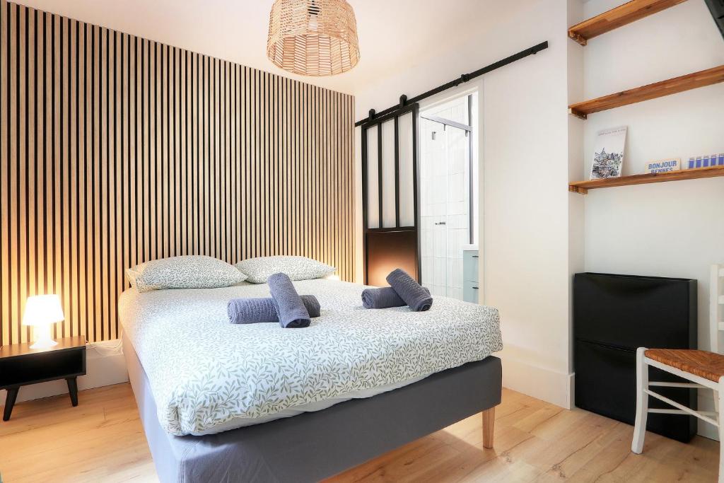 une chambre avec un lit avec des oreillers bleus dessus dans l'établissement Menorca, à Rennes