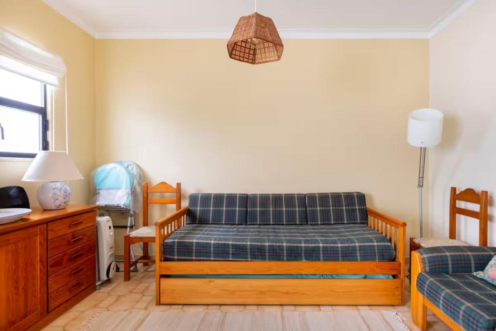 een slaapkamer met een bed, een bureau en een stoel bij Casa das Andorinhas in Ferragudo