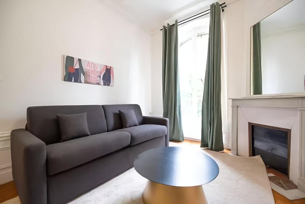 un salon avec un canapé et une table dans l'établissement TBS 316 - Apartment close to Eiffel Tower, à Paris