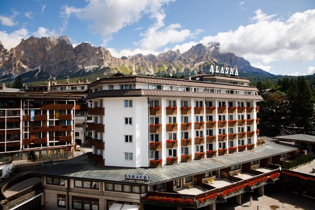 budynek hotelowy z górami w tle w obiekcie Hotel Alaska Cortina w mieście Cortina dʼAmpezzo