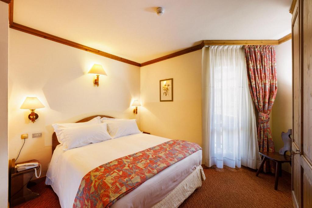 Łóżko lub łóżka w pokoju w obiekcie Hotel Alaska Cortina