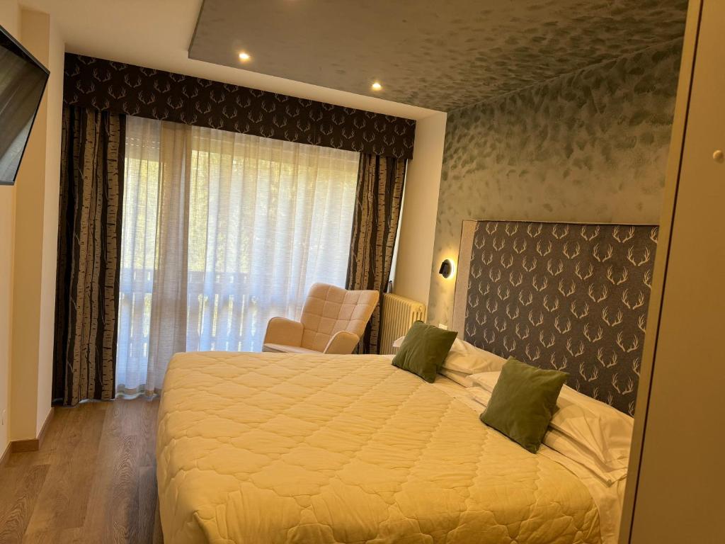 a hotel room with a bed and a window at Hotel Europa in San Martino di Castrozza