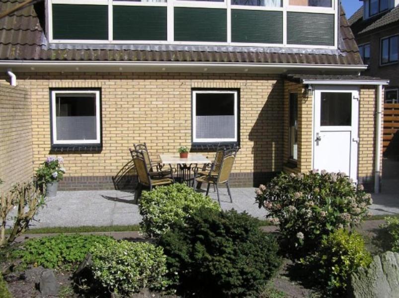 een patio met een tafel en stoelen voor een huis bij Ambla in Nes