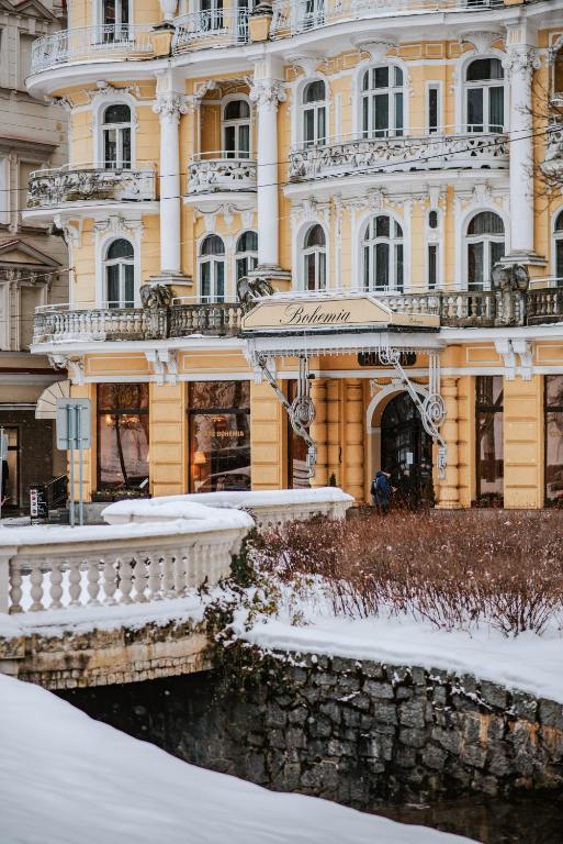 a building with snow in front of it at OREA Spa Hotel Bohemia Mariánské Lázně in Mariánské Lázně