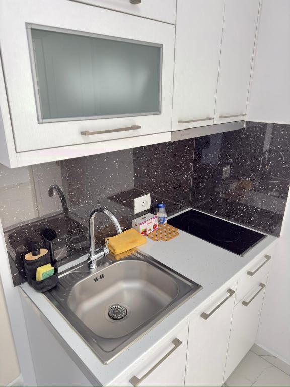 a kitchen with a sink with a tv above it at Villa Denis Ksamil in Ksamil