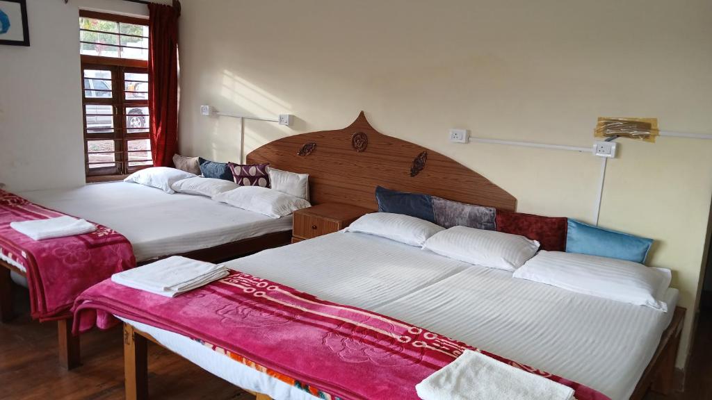 Postel nebo postele na pokoji v ubytování Satya Anand Cottage Pure Veg and Non Alcoholic Hotel