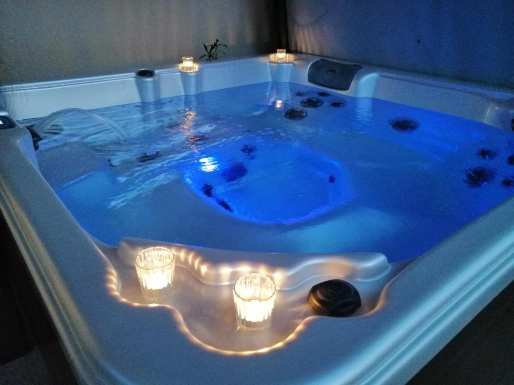 a jacuzzi tub with candles in it at Gîtes Les Nogalies SPA PRIVATIF in Valojoulx
