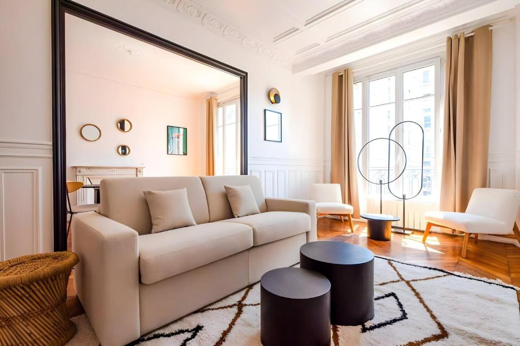 - un salon avec un canapé blanc et un miroir dans l'établissement TBS 322 - Superb apartment with Eiffel Tower view, à Paris