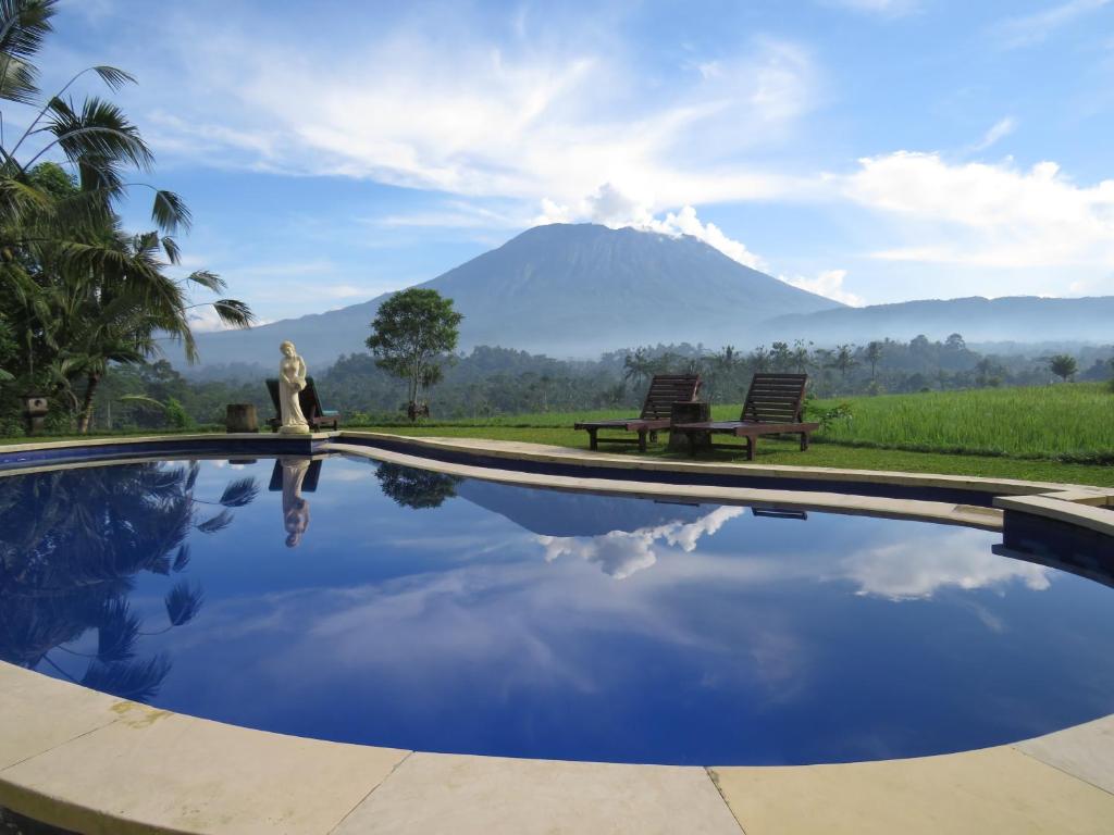 a swimming pool with a mountain in the background at Great Mountain Views Villa Resort in Sidemen