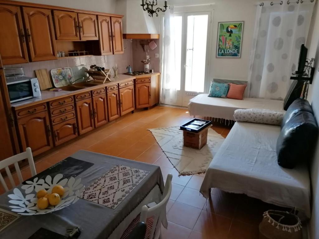 un salon avec un canapé et une table dans l'établissement Aux Papyrus, à La Londe-les-Maures