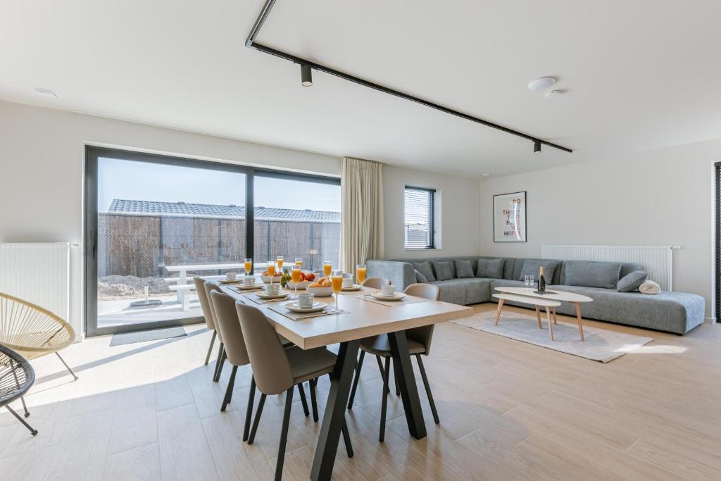a dining room and living room with a table and chairs at Maison Sebastian in Nieuwpoort
