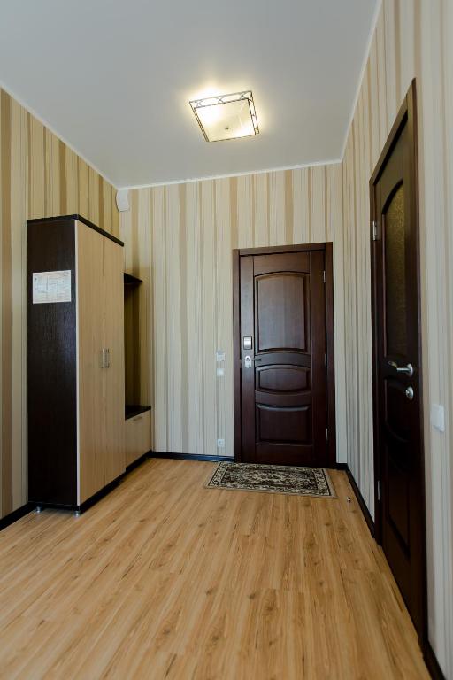 an empty room with wooden floors and a door at Hotel Hizhina in Petropavlovsk