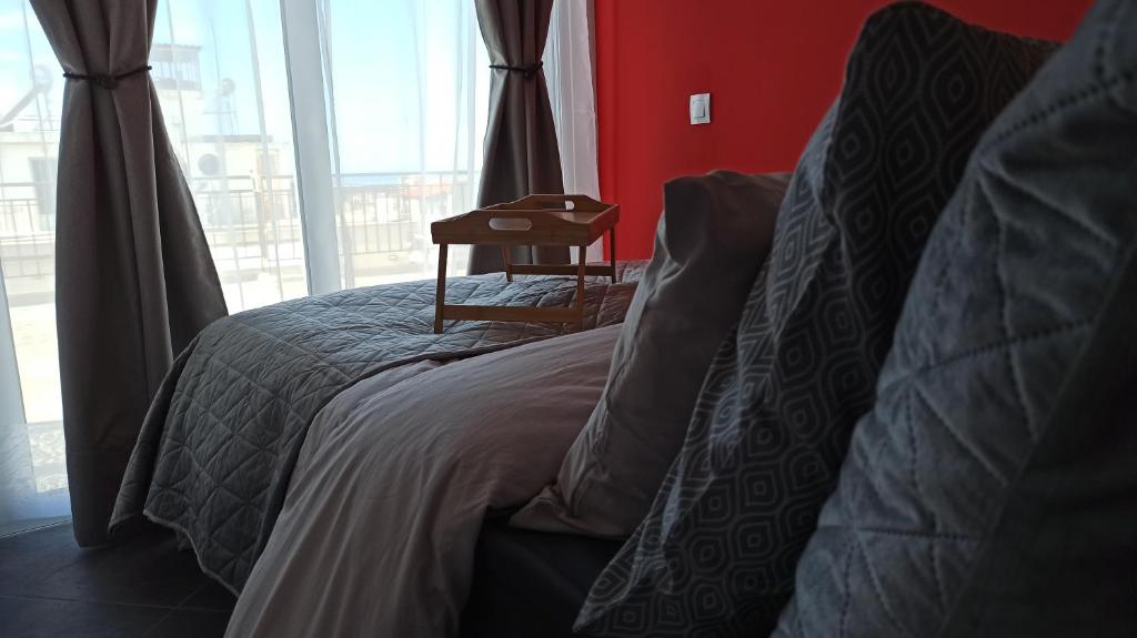 a bedroom with a bed with a table next to a window at House on the Top in Patra