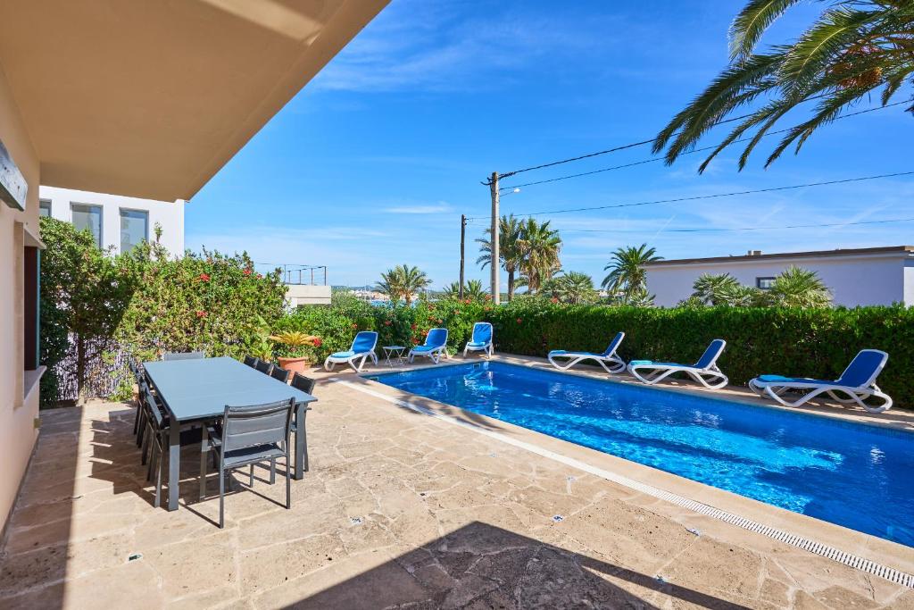 a patio with a table and chairs next to a swimming pool at Villa Mesquida in Portocolom