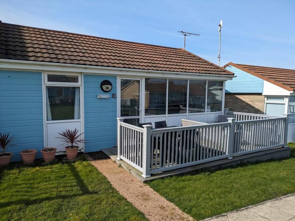 ウエストワード・ホーにあるChalet Ho!の白いポーチ付き小さな青い家