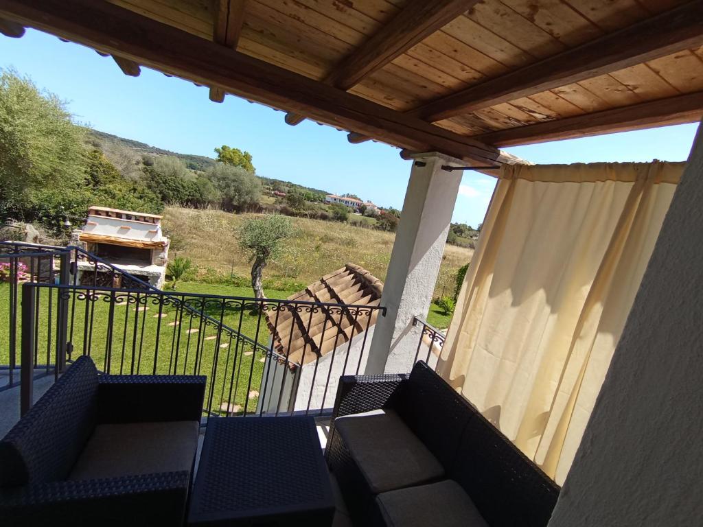 a porch with chairs and a fence and a view at Gibilo's home in Bari Sardo