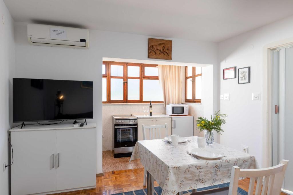 un salon avec une table et une cuisine dans l'établissement Guest House Vulić, à Dubrovnik