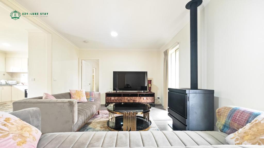 Una sala de estar con un sofá y una chimenea. en Marysville Adventure Retreat, en Marysville