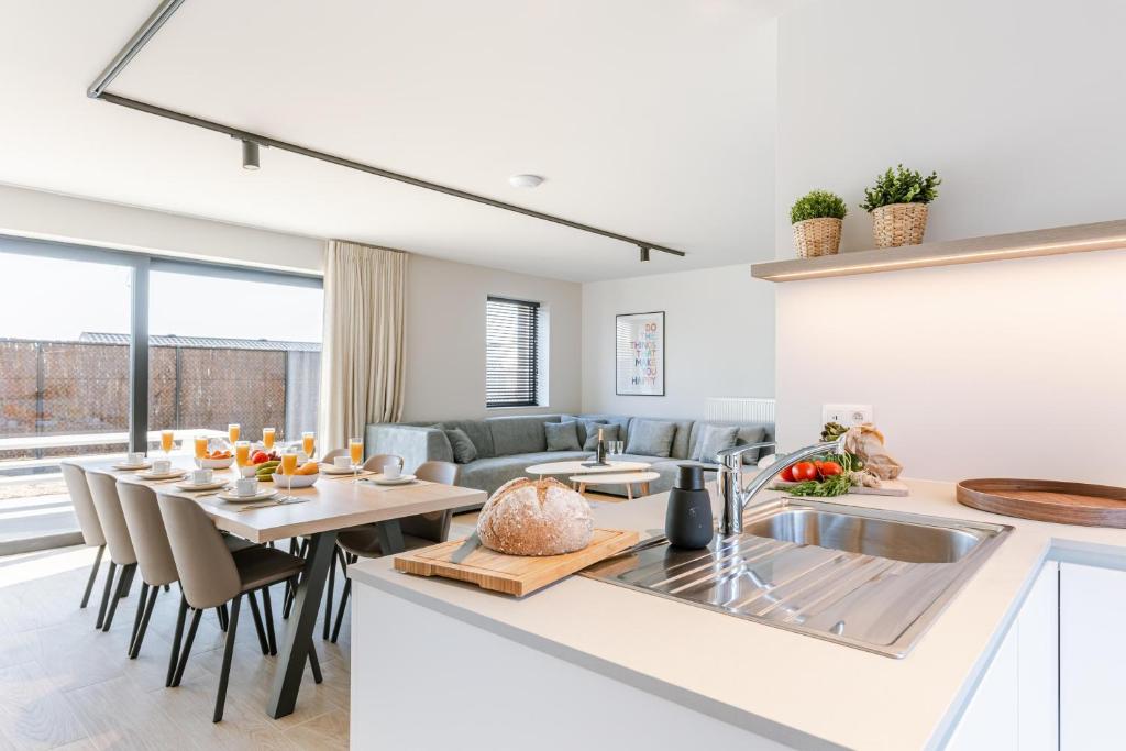 a kitchen and living room with a table and a sink at Maison Atlantis in Nieuwpoort