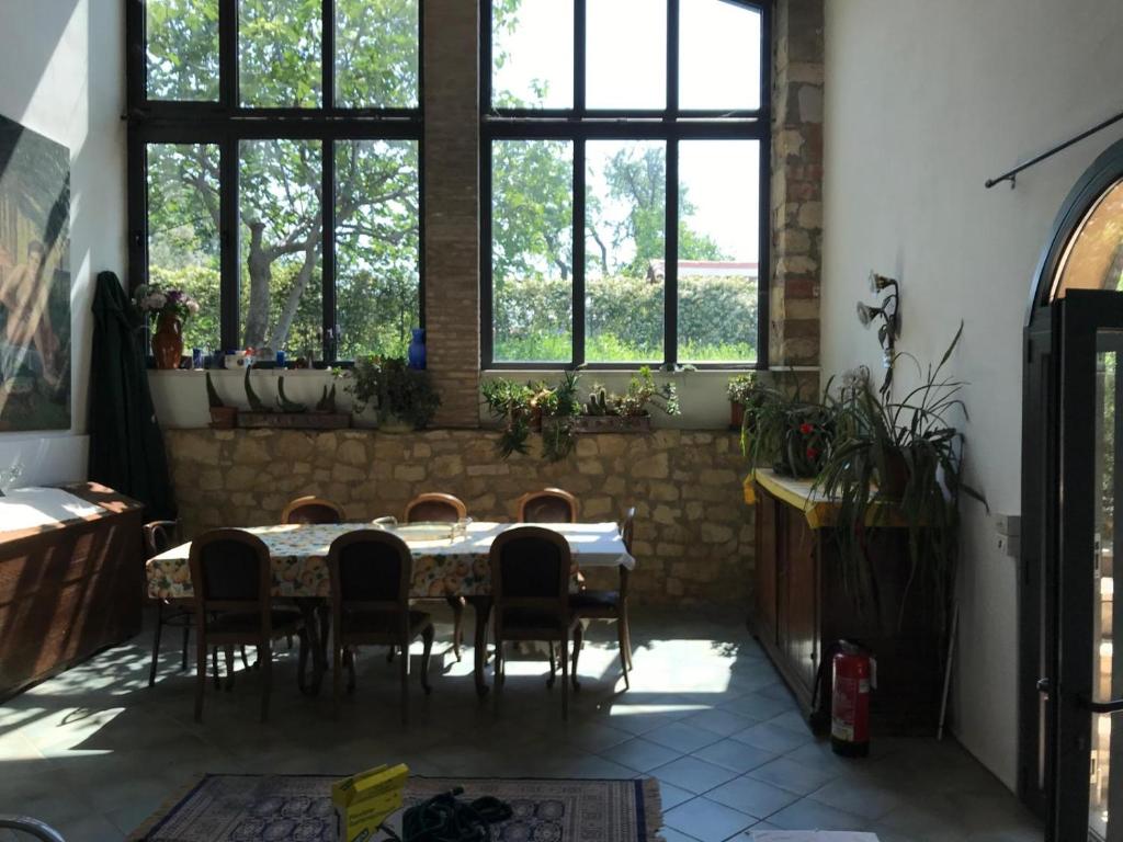 a table and chairs in a room with windows at Villa in Valpolicella in San Pietro in Cariano