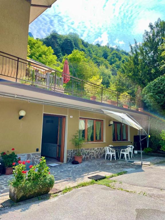 a house with a balcony and a table and chairs at Idro Appartamenti - Vantone in IDRO