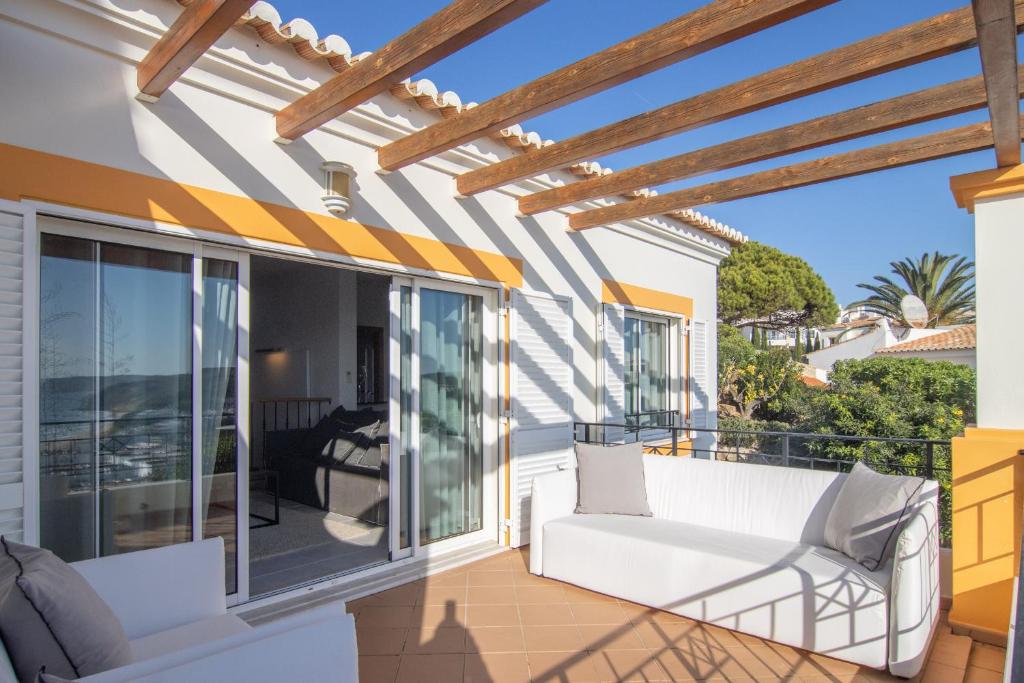 a patio with a white couch on a balcony at The View – Santo António Villas, Golf & Spa in Salema