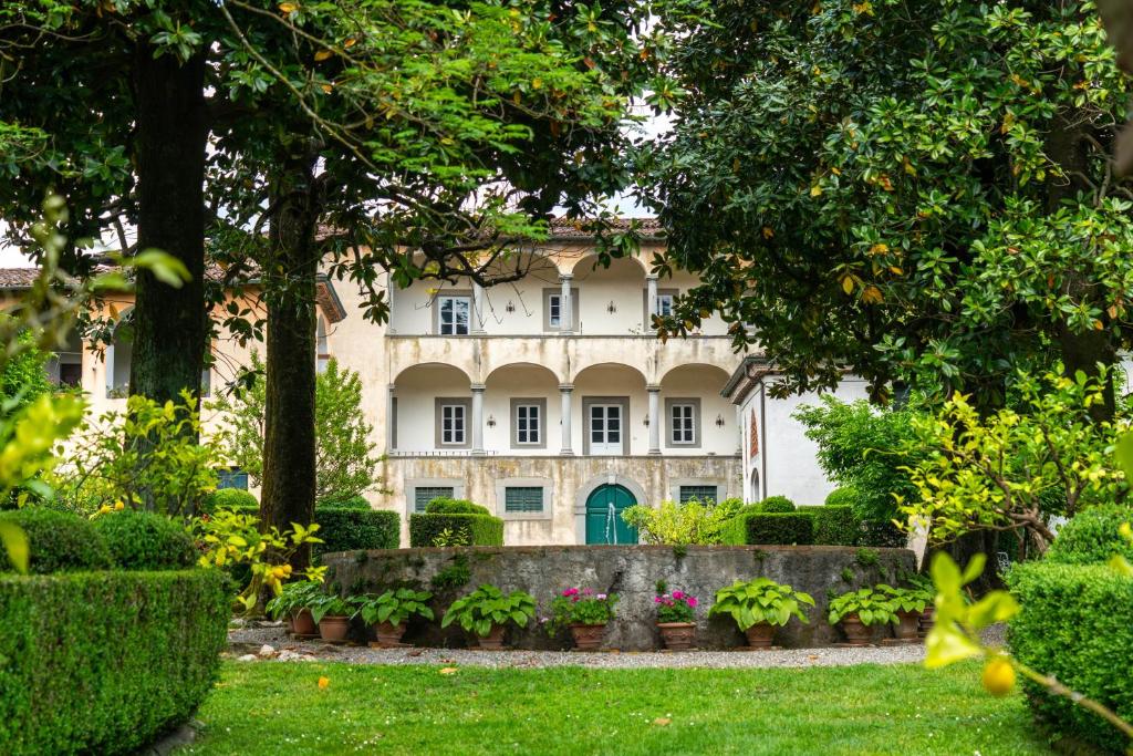 an old house with a garden in front of it at Case Bernardini Suites in Ghivizzano