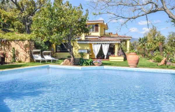 une grande piscine devant une maison dans l'établissement GreenVilla, à La Caletta