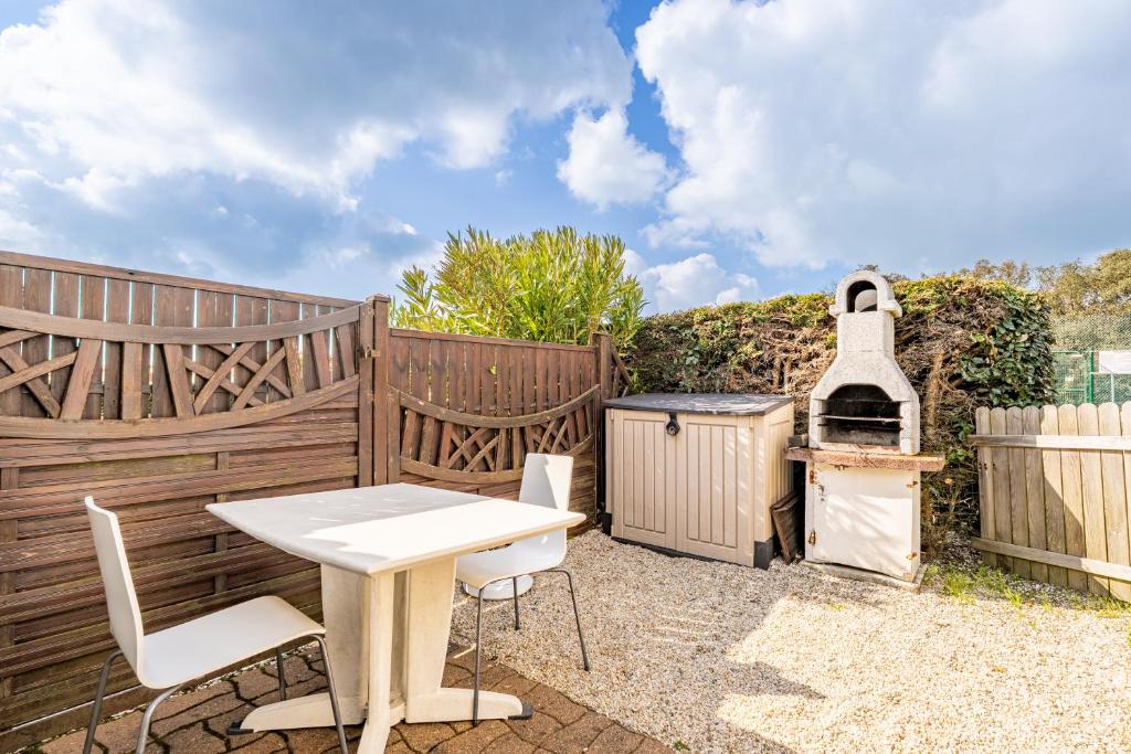 ポルニックにあるM9107 - Domaine, Maison 4 Persのテーブルと椅子とグリルのあるパティオ