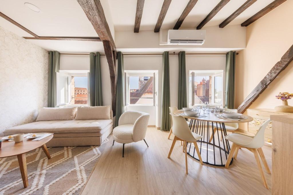 ein Wohnzimmer mit Sofa und Tisch in der Unterkunft L’Alcôve Bourbonnaise - Au coeur de Montluçon in Montluçon