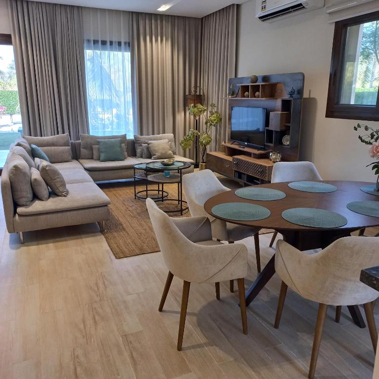 サラーラにあるGarden Villa - Hawana Salalahのテーブルと椅子とテレビのあるリビングルーム