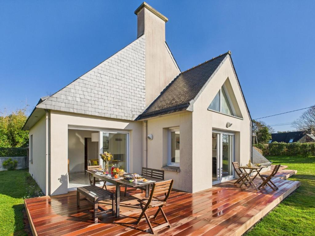une maison avec une terrasse avec une table et des chaises dans l'établissement -NAYA- Maison familiale a deux pas de la mer, à Trégunc