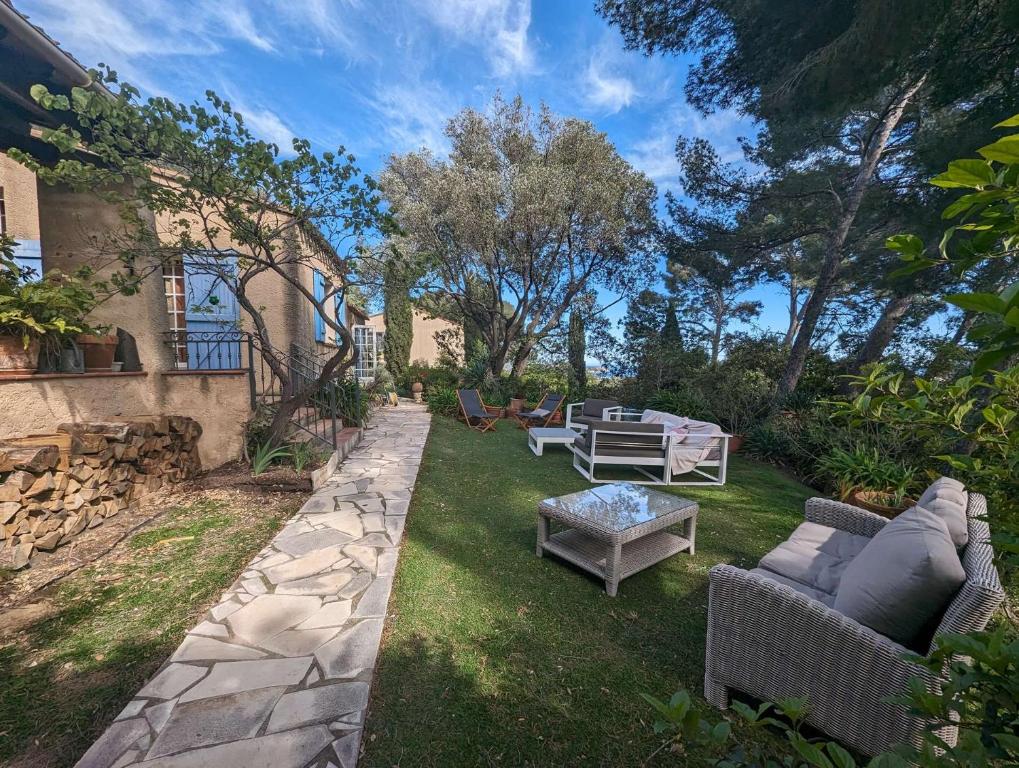 une cour avec des canapés, une table et des chaises dans l'établissement Maison provençale 4 chambres entre Six Fours les plages et les Sablettes, à La Seyne-sur-Mer