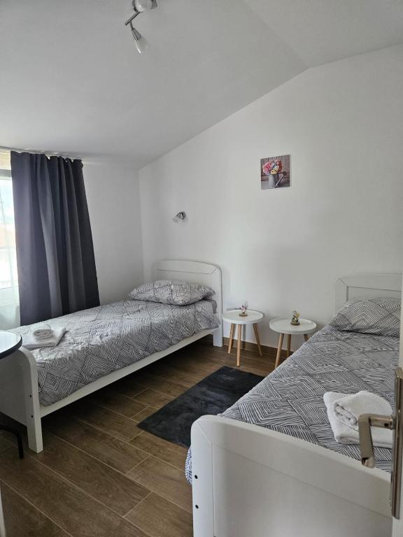 a bedroom with two beds and two tables at Apartman Tamaris in Vir