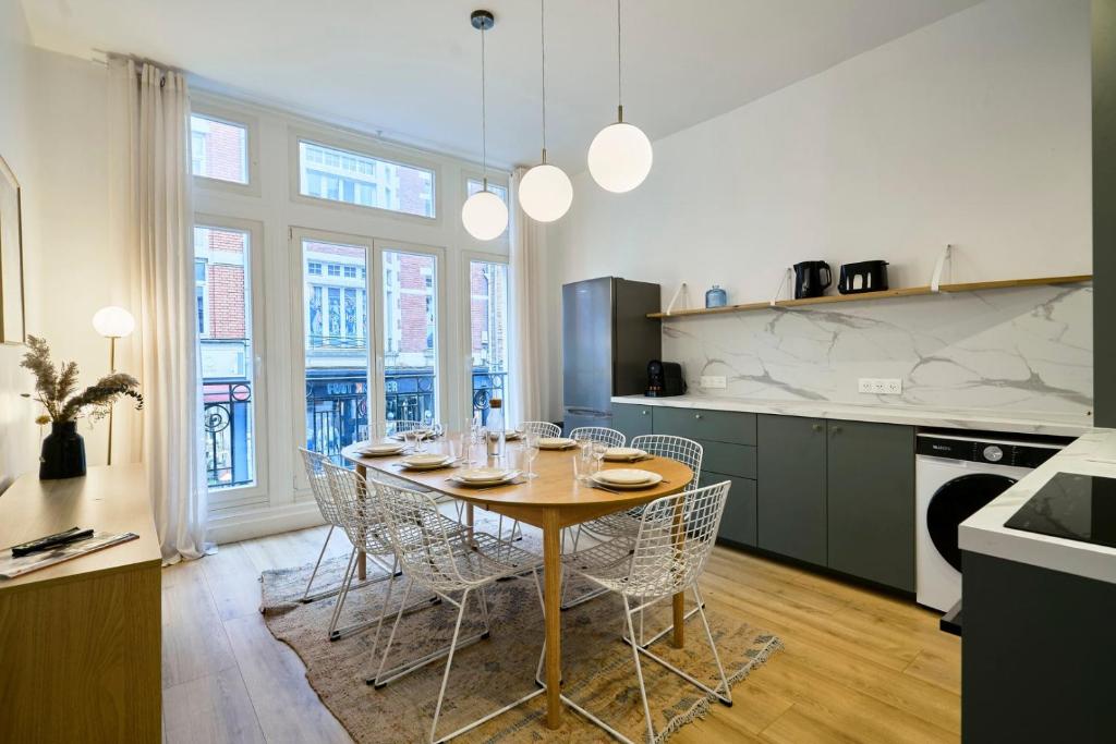 ein Esszimmer mit Tisch und Stühlen in einer Küche in der Unterkunft Maison 5 chambres & 5 sdb proche métro & commerces in Lille