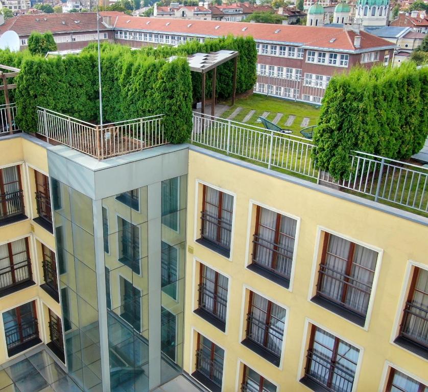 an apartment building with a balcony on the top of it at ATRIUM Boutique Suites Sofia in Sofia