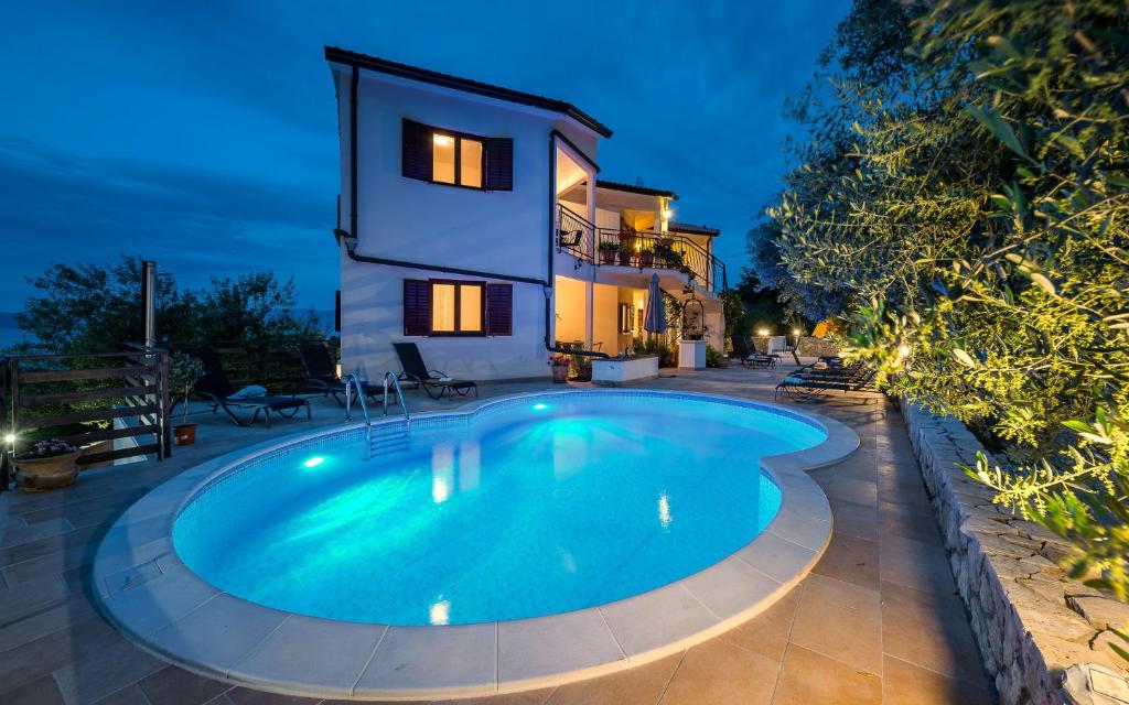 a swimming pool in front of a house at Klaudio Aqua Oaza Drenje in Drenje