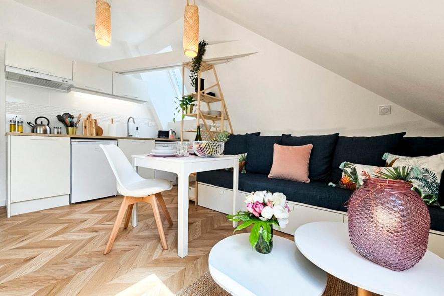 a living room with a couch and a table at L'Eden - calme et luminosité au coeur de la ville in Fougères