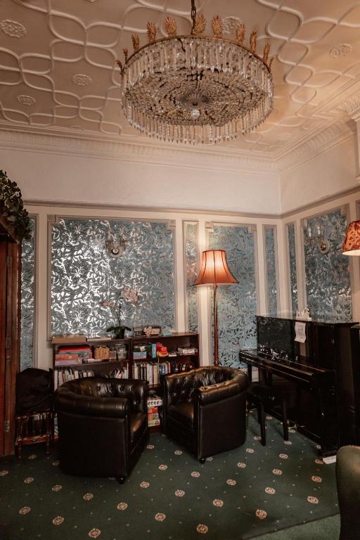 a living room with chairs and a chandelier at London Visitors Hotel in London