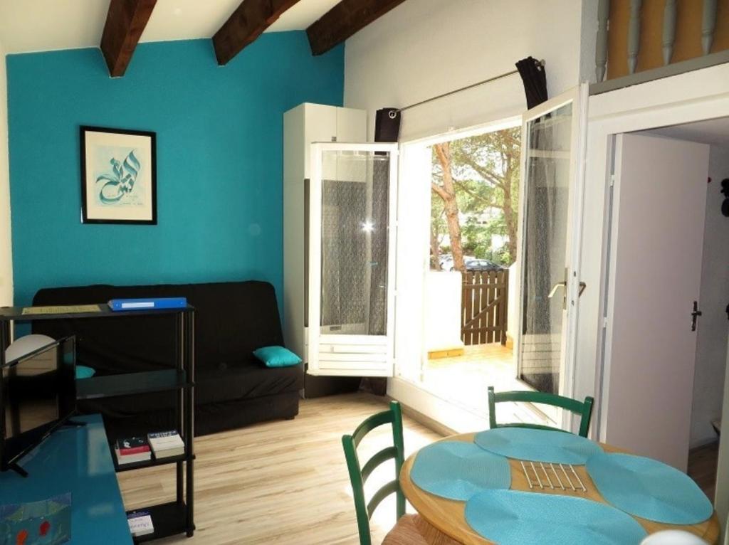 un salon avec une table et un canapé dans l'établissement Appartement saisonnier à la semaine, au Cap d'Agde