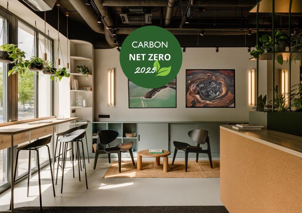 a cafe with chairs and a sign that reads carbon net zero at PLANTONIA Aparthotel in Kraków