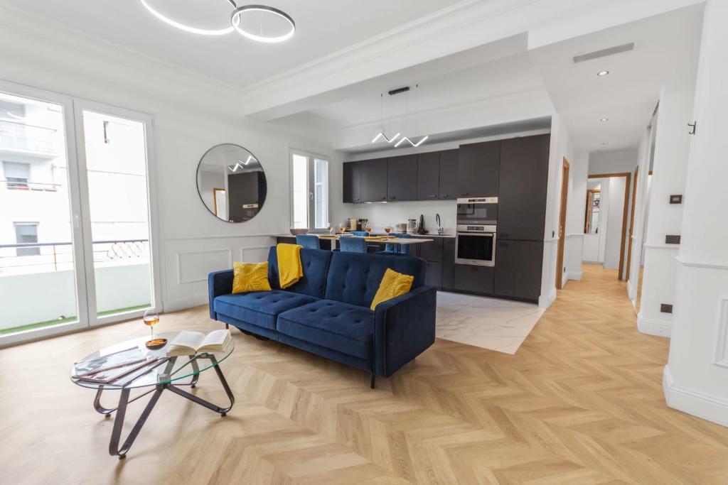 un salon avec un canapé bleu et une cuisine dans l'établissement Le Versailles - Hypercentre - Luxurious - Spacious - AC, à Antibes