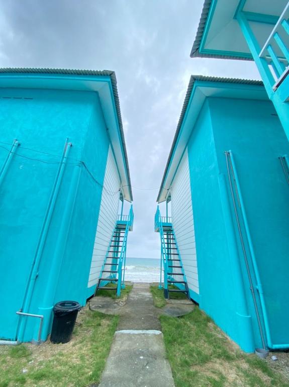 a pair of blue buildings next to the ocean at Pondok Beach Shack in Tioman Island