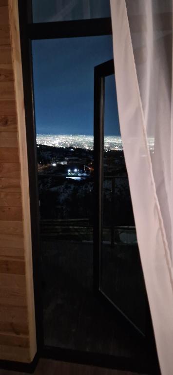 a window in a room with a view of the city at Dream house Almaty in Almaty