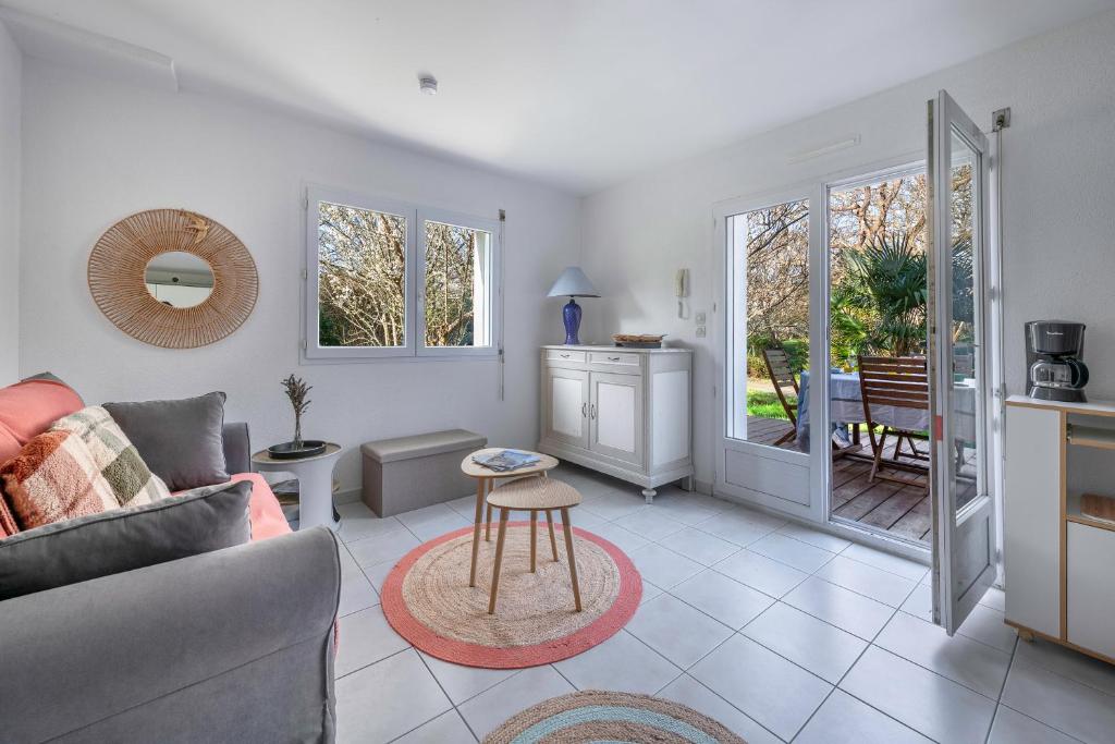 un salon avec un canapé et une table dans l'établissement Appartement avec jardin à 300m de la plage, pour 4, à Pornic
