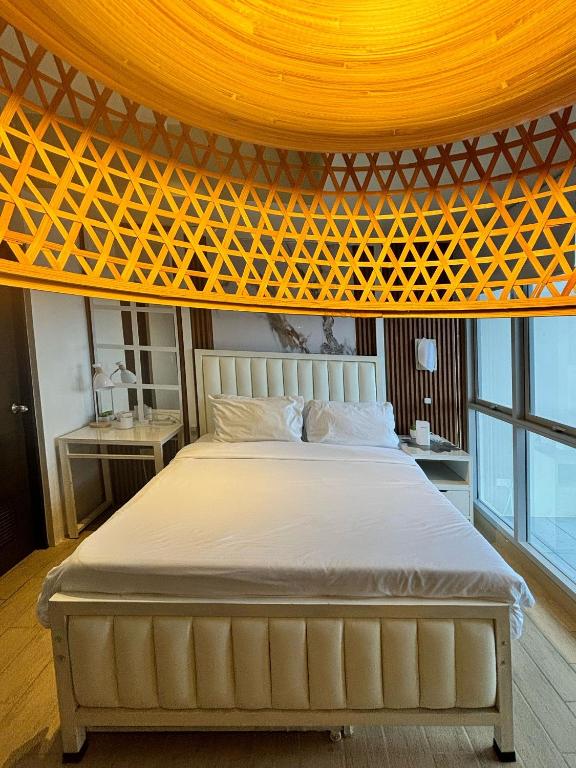 a bedroom with a large bed with a yellow ceiling at Serenity Staycation Studio in Iloilo City