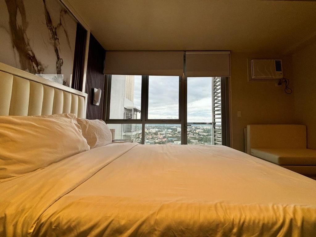 a large white bed in a room with a window at Serenity Staycation Studio in Iloilo City