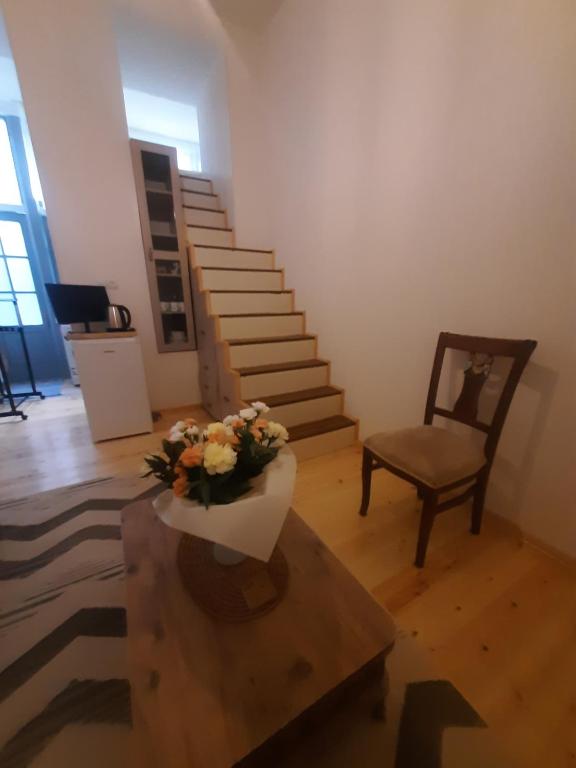 a living room with a table with a vase of flowers at Sweet Home in Tbilisi City